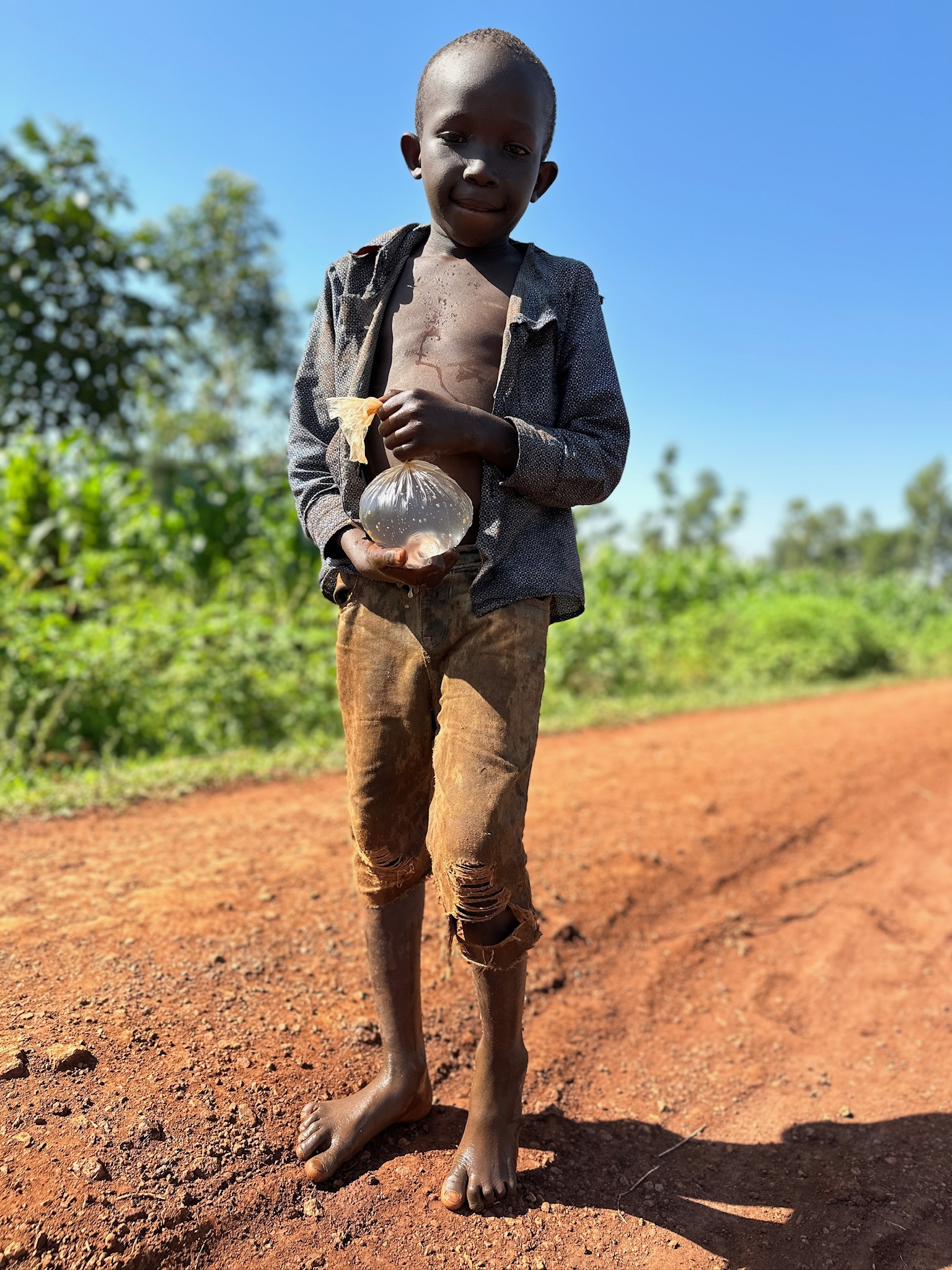 Young child from Kodema Village standing on a dirt road